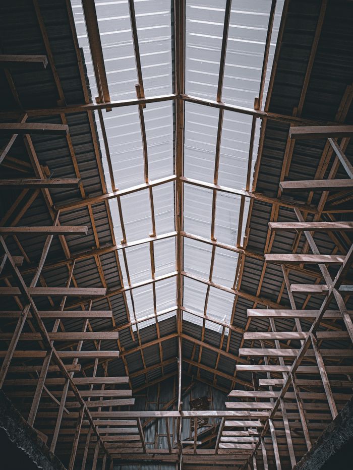Viewing the intricate wooden framework supporting a warehouse ceiling.